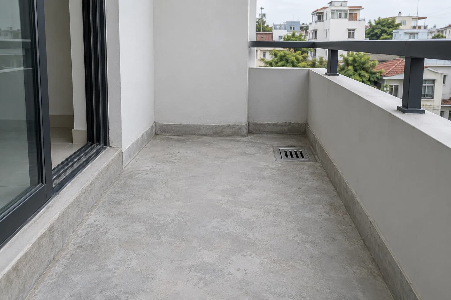 Ban công nền xi măng với phễu thoát nước, ngưỡng cửa và chân tường